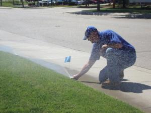 Grapevine irrigation contractor checks a pop up sprinkler head
